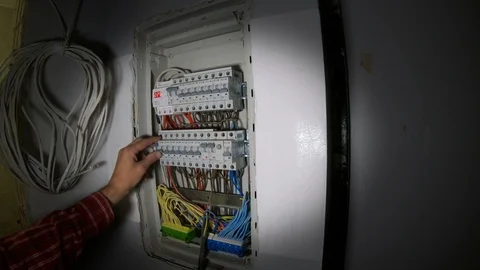 A man uses a switchboard with an electric machine.  Electrical circuit breakers Vidéo 120286047