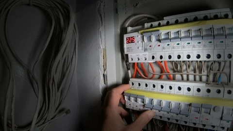 A man uses a switchboard with an electric machine.  Electrical circuit breakers Video stock 120286184