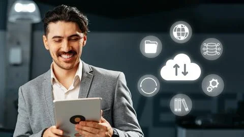 Man uses tablet to access cloud services in a modern office during daytime 스톡 사진