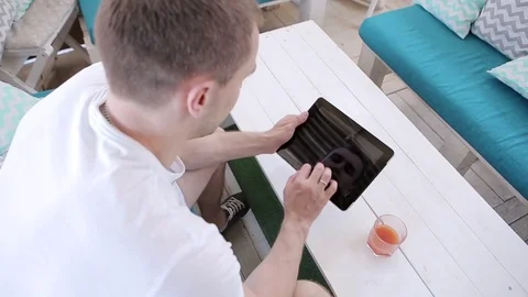 Man Uses a Tablet And Drinks Juice  Stock Footage 82442620