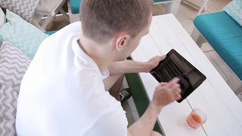 Man Uses a Tablet And Drinks Juice  Stock Footage 82442622
