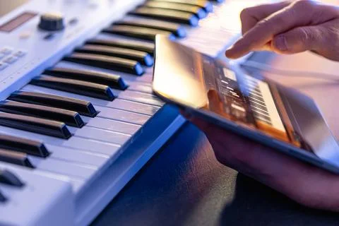 A man uses a tablet with an application for recording music. Stock Photos