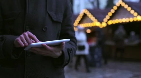 Man uses a tablet in the city in winter Stock Footage 60004876