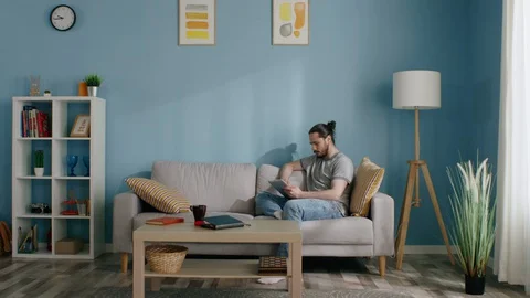Man Uses Tablet Computer at Home Video stock 129888737