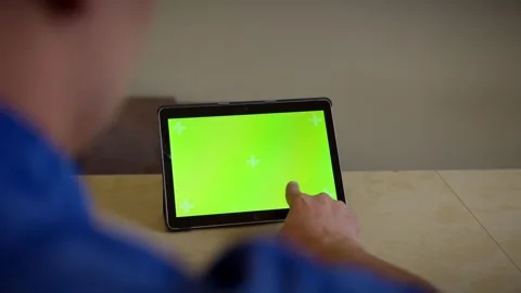 Man uses a tablet with a green screen presses his finger on the screen touches Stock Footage 267420328