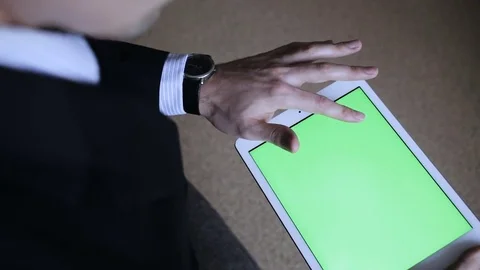 A man uses a tablet PC at his desk. Chroma key screen for placement of your own Video stock 83458518