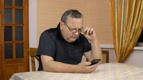 A man uses a telephone for the first time. The old man hardly dialed the number Stock Footage 124656210