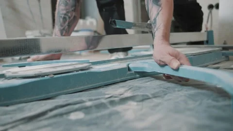 Man uses tool to smooth tile surface in workshop during home renovation project Stock-Footage 317377987