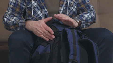 A man uses a tourist backpack instead of a drum and knocks on it with his palms Stock Footage 103956809