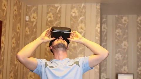 Man uses a virtual reality helmet. Standing in the room Stock Footage 72582491