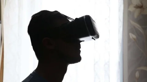 Man uses a virtual reality helmet. Silhouette Stock-Footage 72582851