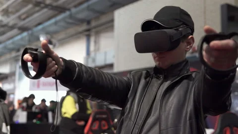 A man uses a virtual reality helmet with regulator handles Stock Footage 109105149