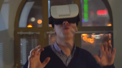 Man uses VR goggles in the background of city lights Stock Footage 72294408