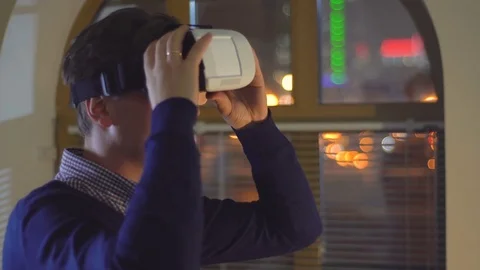 Man uses VR goggles in the background of city lights Stock Footage 72296222