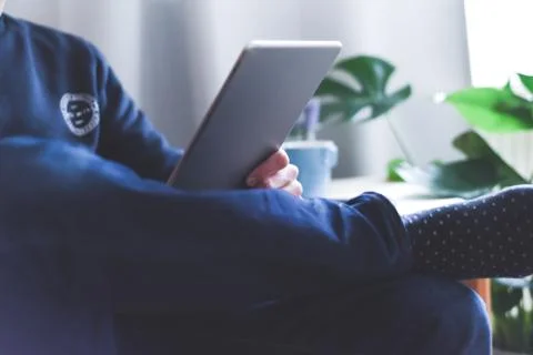 A man uses a wireless tablet device at home to check email and social media m Stock Photos