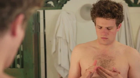 Man using after-shave in front of mirror Stock Footage 40844417