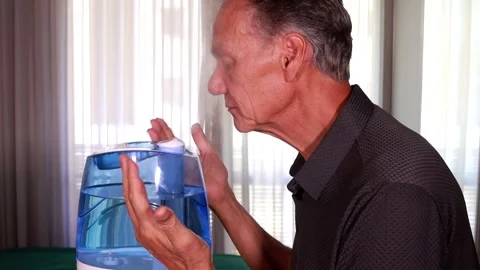 Man using an air humidifier to help him breath in dry weathe Stock Footage 283128732