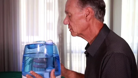 Man using an air humidifier to help him breath in dry weathe Stock Footage 283129090