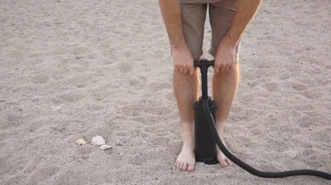Man Using Air Pump on Sandy Beach Stock Footage 39720441