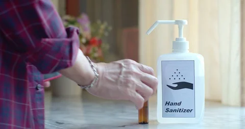 Man using alcohol spray and transparent sanitizer in pump bottle Stock Footage 128410160