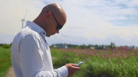 Man using and scrolling phone and looks around on the background of the a Stock Footage 115133207