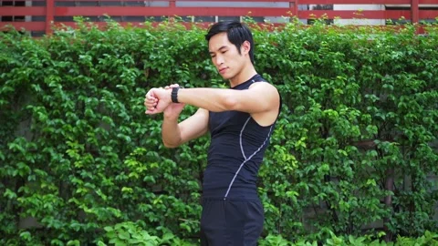 Man using and setting smart watch before running in the park Stock Footage 132406951