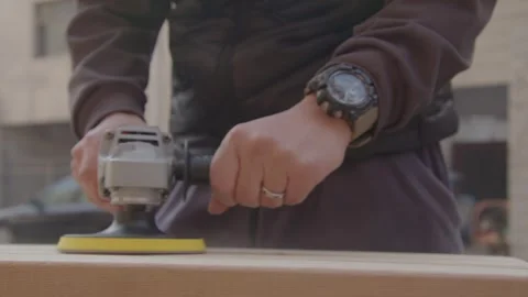 Man Using Angle Grinder to Sand Wooden Plank Outdoors Stock Footage 336561449