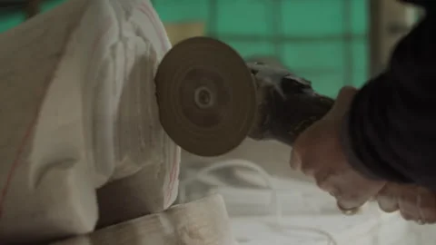 Man using an angle grinder while sculpturing stone Stock Footage 275000240