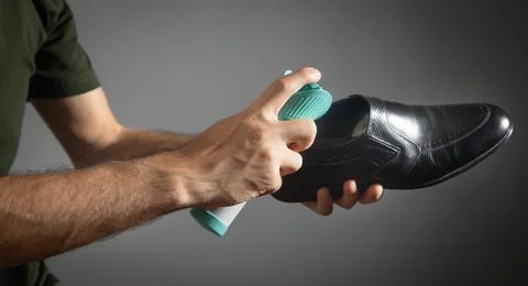 Man using antibacterial spray against unpleasant odors. Stock Photos