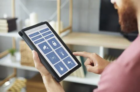 Man using an app on a modern tablet computer to control the system of his Smart Stock Photos