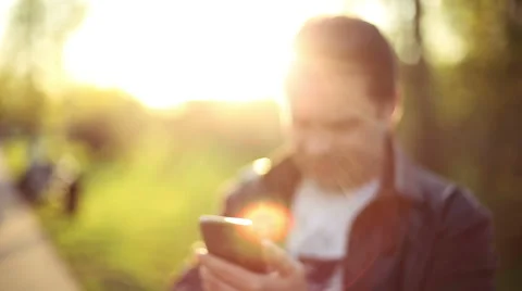 Man using app on Smart Phone at Sunset. Blur. Out of Focus. HD 1080. Stock Footage 49751405