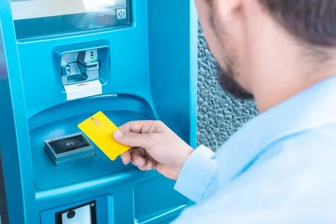 Man using atm machine puts credit card business for cash. Finance bank account. Stock Photos