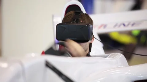 Man using auto simulator with virtual glasses in game center Stock Footage 64766318