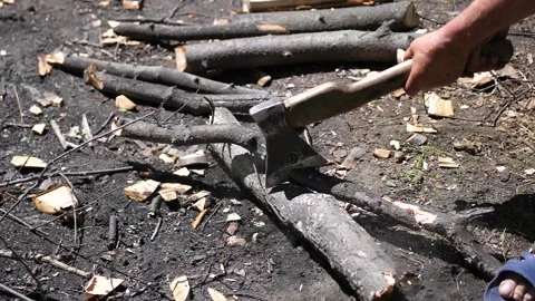 A man using an ax to chop wood for a fire. Outdoor recreation 库存影片 92798216