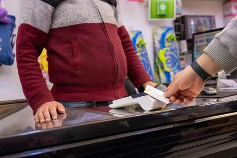 Man using bank card through NFC or WIFI or touch less to pay in bookshop or.. Stock Photos