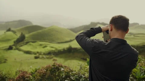 Man Using Binoculars to View Lush Green Hills in Portugal Stock Footage 344856601