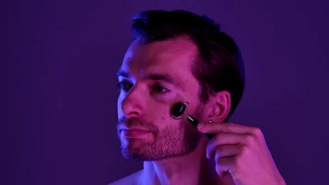 Man Using Black Jade Roller for Facial Skincare Routine Stock Footage 310492460