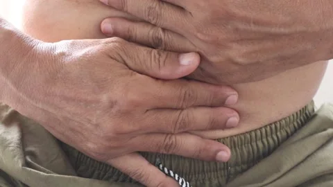 Man is using both hands to hold the abdomen due to severe pain Stock Footage 146251000
