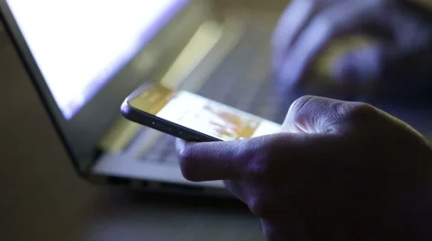 Man using both laptop and smartphone at night in a dark space. Stock Footage 51709355