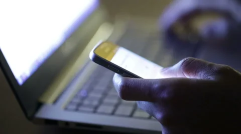 Man using both laptop and smartphone at night in a dark space. Video stock 51709377