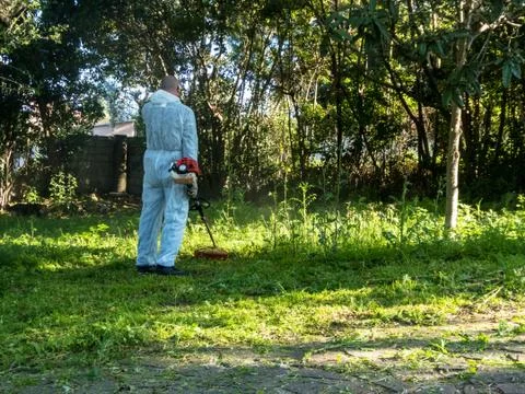Man using brush cutter Stock Photos