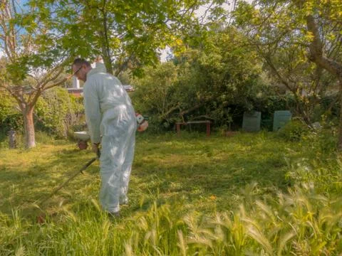 Man using brush cutter Stock Photos