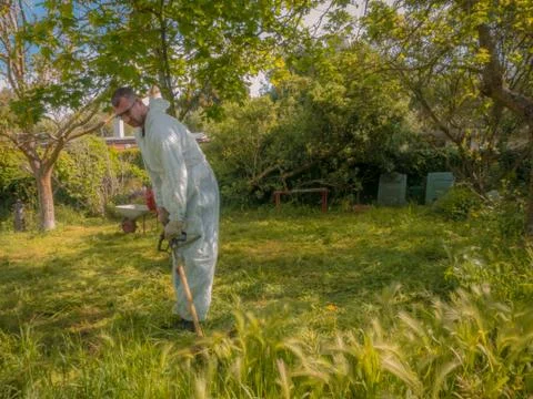Man using brush cutter Stock Photos