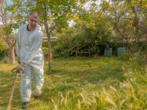 Man using brush cutter Stock Photos