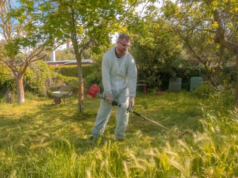 Man using brush cutter Stock Photos