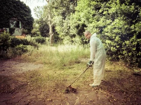 Man using brush cutter Stock Photos