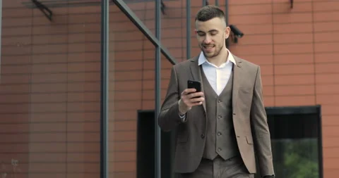 Man using business app on smart phone walking in city. Handsome young Stock Footage 91000923