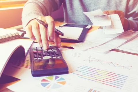 Man using calculator and calculate cost with holding bill in home office. Stock Photos