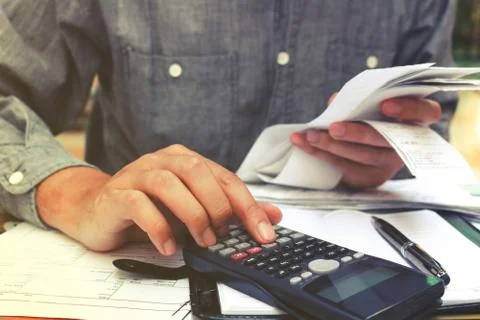 Man using calculator and calculating bills in home office. Stock Photos