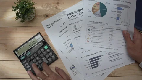Man using a calculator and reviewing financial reports Stock Footage 346771287
